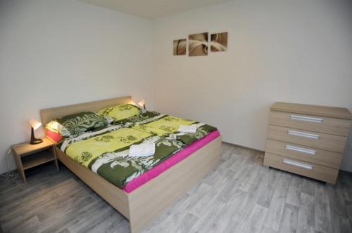 a bedroom with a bed and a dresser and a night stand at Apartmán Zuzka in Jeseník