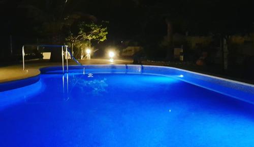 a large blue swimming pool at night at Beach Resort La Margarita in Hospitalet de l'Infant
