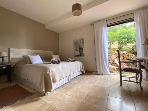 a bedroom with a bed and a table and a window at Les Mas d'Azur Appartement in Vence