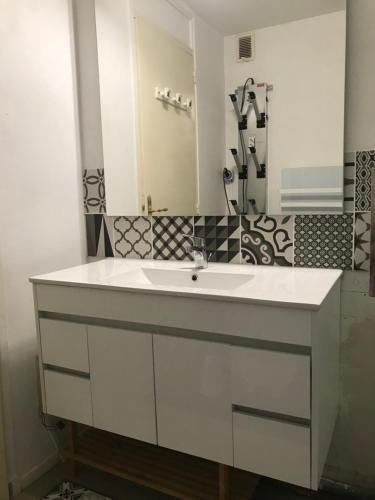 La salle de bains est pourvue d'un lavabo blanc et d'un miroir. dans l'établissement grand studio 7 couchages entièrement rénové, à Forest des Baniols