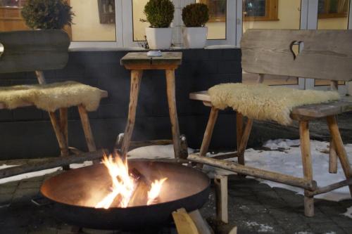 a fire pit with two chairs and a table at Hotel Feyrer in Senden