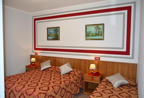 a hotel room with two beds and two lamps at Hotel Facioni in Pomezia