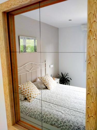 a room with a bed with a glass wall at Vivienda Turístico Erreka Beach in Mundaka
