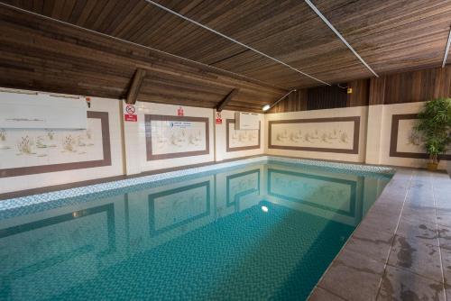 a large swimming pool in a building with at Beach Hut Suites in Bognor Regis
