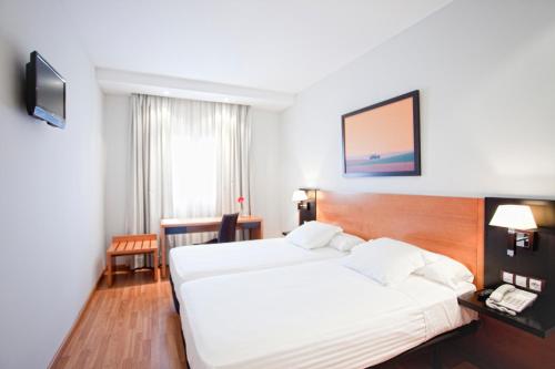 ein Hotelzimmer mit 2 Betten und einem Telefon in der Unterkunft Cortijo Chico Málaga Airport in Alhaurín de la Torre