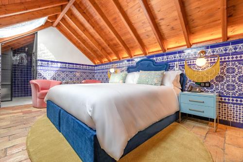 a bed in a room with blue and white tiles at Hotel Claude Marbella in Marbella