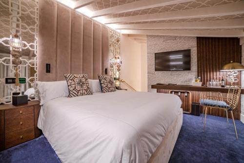 a bedroom with a large white bed and a desk at Hotel Claude Marbella in Marbella