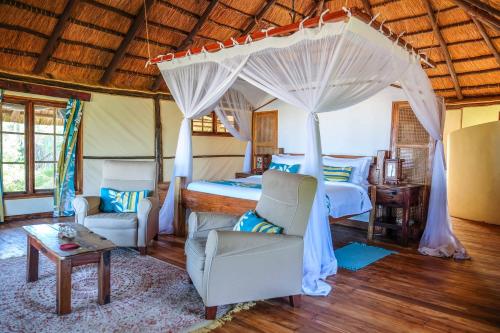 ein Schlafzimmer mit einem Himmelbett in der Unterkunft Saadani Safari Lodge in Saadani