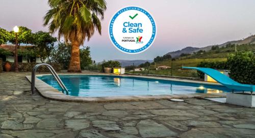 a swimming pool with a sign that says clean and safe at Quinta da Padrela Winery House in Tabuaço