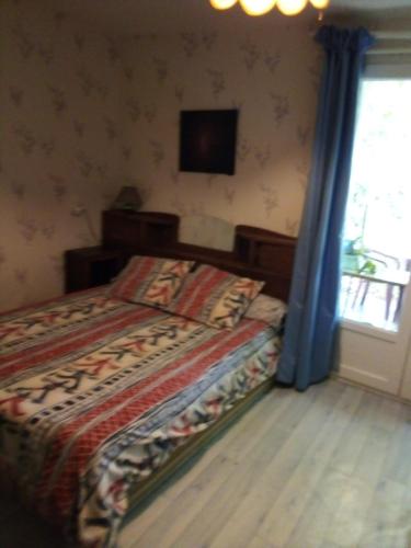 - une chambre avec un lit et une télévision murale dans l'établissement la Belle Charentaise, à Mainxe