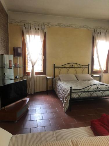sypialnia z łóżkiem i 2 oknami w obiekcie La Suite del Doge w mieście Treviso