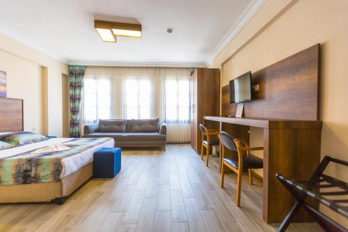 クシャダスにあるOLD TOWN BOUTIQUE HOTELのベッドとソファ付きのホテルルーム