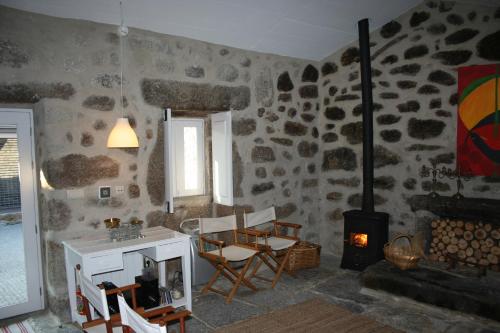 a living room with a table and chairs and a stove at Cazal Da Lamella in Fafe