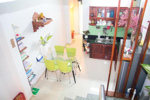 a dining room with a table and yellow chairs at Kota's House Homestay in Hue
