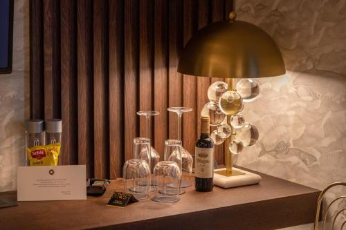 a table with wine glasses and a lamp on it at Hotel Claude Marbella in Marbella
