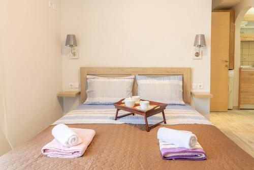 a bedroom with a bed with towels and a table at The Holiday Studio in Agios Nikolaos