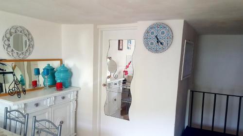 a room with a clock on a white wall at La Casa Sugli Archi in Ponza