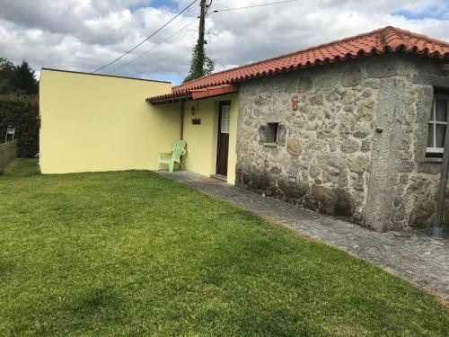 a house with a green chair in front of it at Casa da Ponte do Porto in Amares