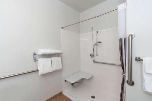 a white bathroom with a shower and a sink at La Quinta by Wyndham Rifle in Rifle