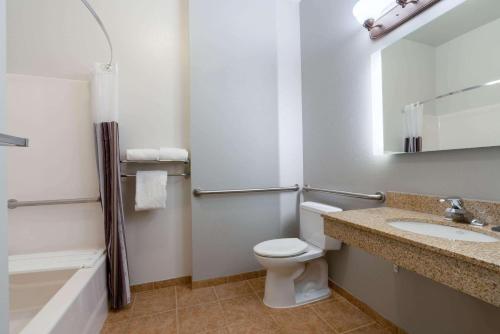 a bathroom with a toilet and a sink and a tub at La Quinta by Wyndham Rifle in Rifle