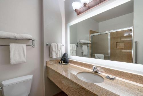 a bathroom with a sink and a toilet and a mirror at La Quinta by Wyndham Rifle in Rifle