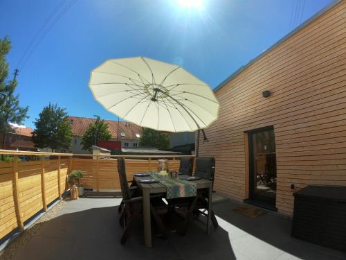 a table and chairs with an umbrella on a patio at Ferienhaus Paradiso in Kirchheim unter Teck