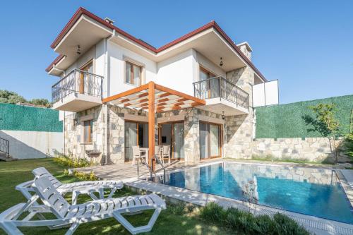 a villa with a swimming pool and a house at Vintage Villas in Kusadası