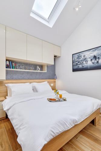 a bedroom with a large white bed with a tray on it at 42° North Apartments in Tivat