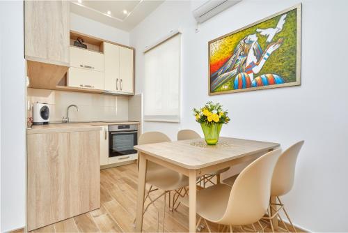a kitchen and dining room with a table and chairs at 42° North Apartments in Tivat
