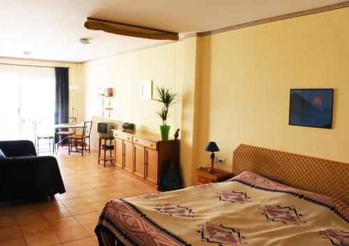 Un dormitorio con una cama y una sala de estar. en Studio Anna - Valle Gran Rey, en Valle Gran Rey