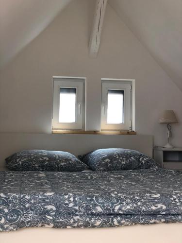 a bedroom with two pillows on a bed with two windows at Ferienhaus Paradiso in Kirchheim unter Teck