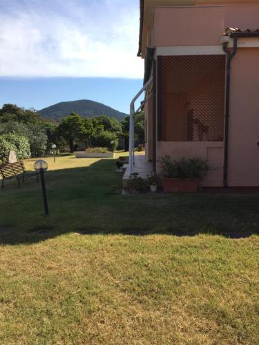 a yard next to a house with a bench at La casa sotto la torre in Chia