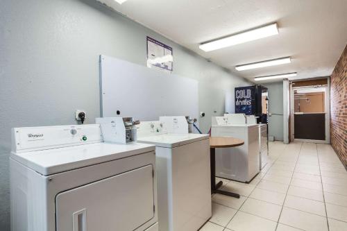 a laundry room with white washers and dryers at Rodeway Inn Lincoln West - University Area in Lincoln