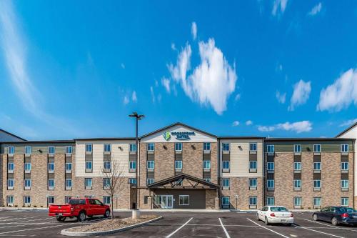 un hotel con un camión rojo estacionado en un estacionamiento en WoodSpring Suites Indianapolis Zionsville, en Whitestown