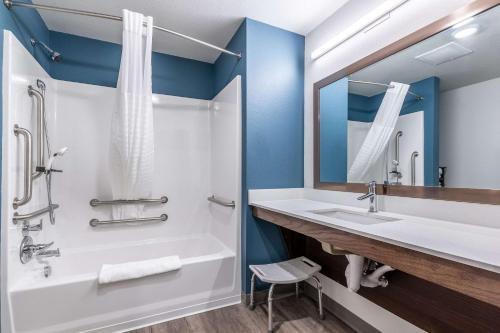 bagno con vasca, lavandino e specchio di WoodSpring Suites Indianapolis Castleton a Indianapolis