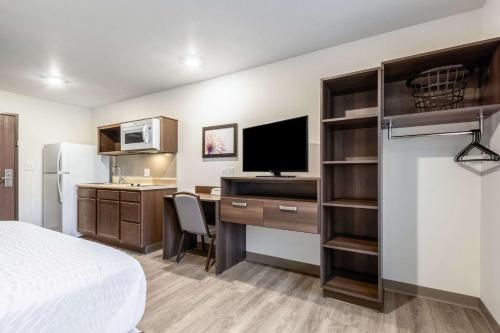 a hotel room with a bed and a desk with a computer at WoodSpring Suites Indianapolis Castleton in Indianapolis