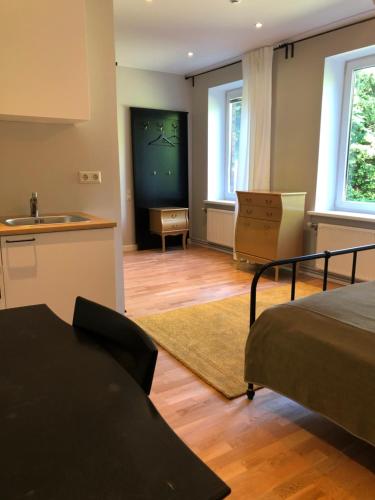 a bedroom with a bed and a kitchen with a sink at Seven Sisters Apartments in Liepāja