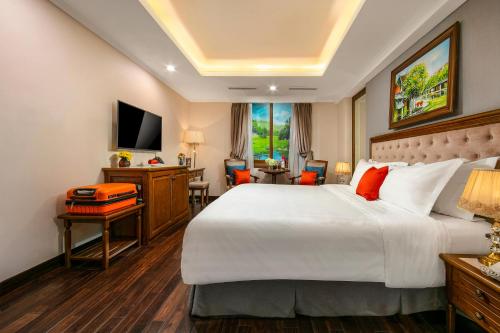 a hotel room with a large bed and a desk at Hanoi Dalvostro Valentino Hotel & Spa in Hanoi