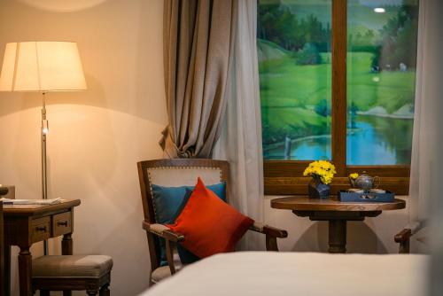 a bedroom with a bed and a desk and a chair with a pillow at Hanoi Dalvostro Valentino Hotel & Spa in Hanoi