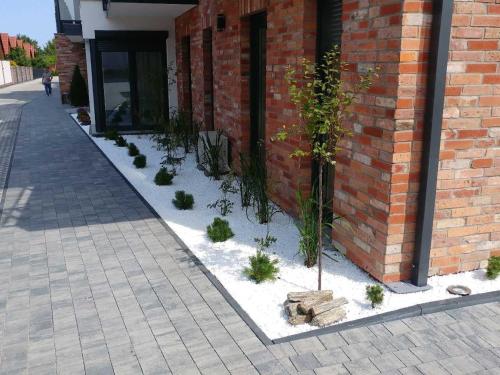 une cour avec des plantes devant un bâtiment dans l'établissement Apartament u Brydzi Apartt99, à Łeba