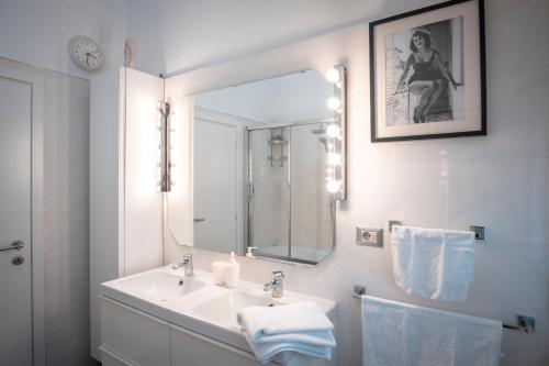 a white bathroom with a sink and a mirror at Civico 8 B&B - Appartamento in Parma