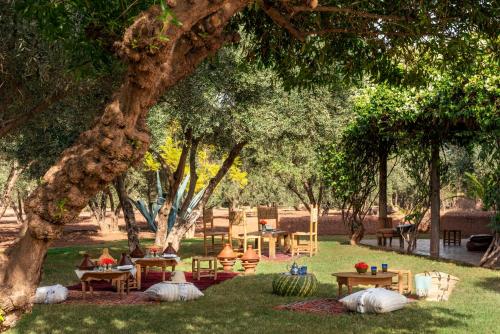 a park with tables and chairs under a tree at Fairmont Royal Palm Marrakech in Marrakech