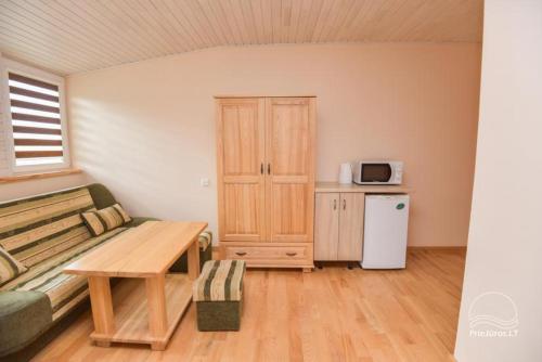 ein Wohnzimmer mit einem Sofa und einem Holztisch in der Unterkunft Pas Eda in Palanga