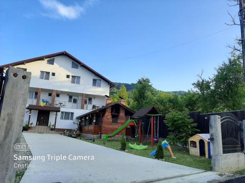 a playground in a yard next to a building at Casa Trache in Călimăneşti