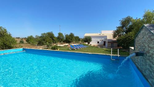 una grande piscina con acqua blu di fronte a una casa di Gold by Check-in Portugal ad Albufeira