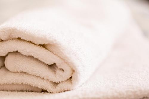 Una pila de toallas blancas sobre una cama. en Green House, en Bucarest