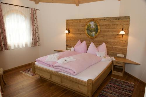 a bedroom with a bed with pink blankets and pillows at Hotel Eggerhof in Saalbach-Hinterglemm