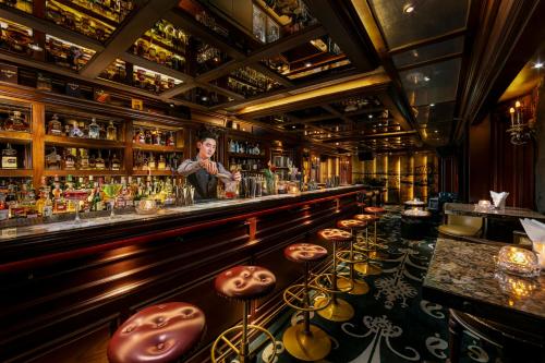 a bar with a woman standing behind the bar at Hanoi Dalvostro Valentino Hotel & Spa in Hanoi