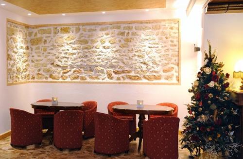 two tables and chairs in a room with a christmas tree at Hotel Paradiso in Asiago