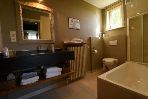 a bathroom with a tub and a sink and a bath tub at Hotel Ter Polders in Damme